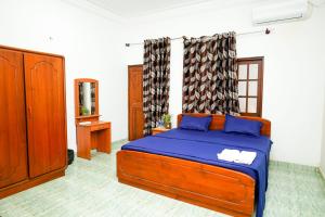 科伦坡The Anam Hotel - Wellawatte的一间卧室配有一张带蓝色床单和镜子的床