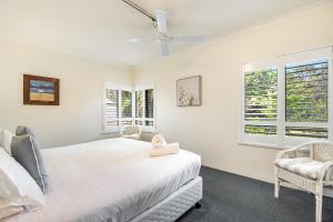 拜伦湾卡普公寓的一间白色卧室,配有床和2个窗户