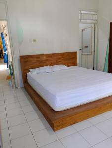 GodeanKluwih House的一间卧室配有一张带木制床架的床
