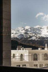 蓬特雷西纳Hotel Maistra 160的享有一座白雪覆盖的群山背景的建筑的景致。