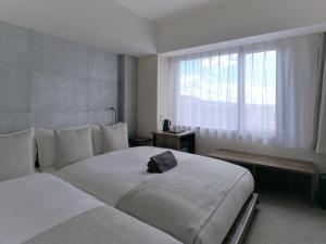 京都Sakura Cross Hotel Kyoto Kiyomizu的酒店客房设有两张床和窗户。