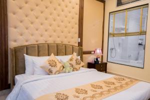 海防Le Haute Hotel Hai Phong的一间卧室设有一张大床和一个窗户。