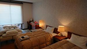 屋久岛海洋蓝屋久岛酒店的酒店客房设有两张床和窗户。