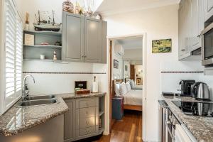 拜伦湾弗朗什海风公寓的厨房配有白色橱柜和水槽