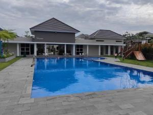 北干巴鲁Sweet City Villa near Mall Pekanbaru Sudirman的一座大蓝色游泳池,位于房子前