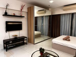 吉隆坡Summer Suites KLCC By Homestay的一间卧室配有一张床、一台电视和一面镜子