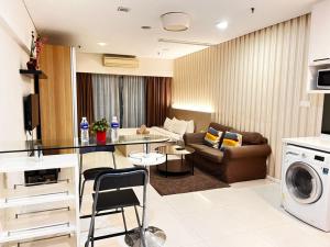 吉隆坡Summer Suites KLCC By Homestay的客厅配有沙发和桌子