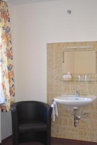 旧天鹅堡加尔尼施罗斯布里克酒店的一间带水槽和黑椅的浴室