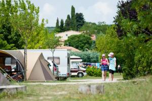 福卡尔基耶Camping Forcalquier les Routes de Provence的两名妇女站在营地前