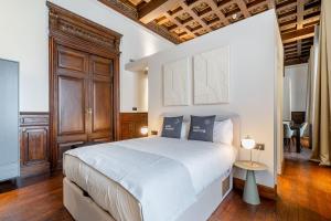 维多利亚-加斯特伊兹limehome Vitoria Palacio de los Álava-Velasco的卧室配有一张白色大床和木制天花板