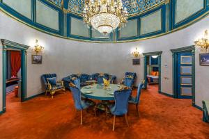巴库Manor Luxury Hotel Baku的一间带桌椅和吊灯的用餐室