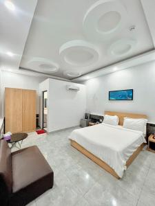 Xóm Phước MỹKhách sạn Khang Điền 2的一间卧室配有一张大床和一张沙发