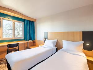 布隆B&B HOTEL Lyon Eurexpo Bron的酒店客房配有两张床和一张书桌