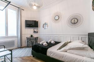 万塞讷MBA Splendide Appart - Mowat - Proche Château de Vincennes的白色卧室配有床和桌子