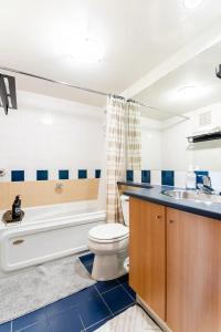 温哥华loft in downtown Vancouver with free parking的浴室配有卫生间、盥洗盆和浴缸。