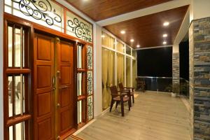 SubrahmanyaGokula Homestay的走廊设有木门和桌椅