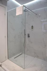 地拉那Metro Hotel Terminal的浴室里设有玻璃门淋浴