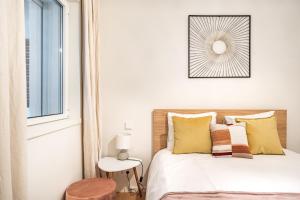 里斯本Akicity Saldanha City的一间卧室配有一张带黄色枕头的床和一扇窗户