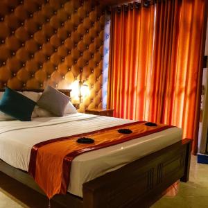 MawatagamaMiracle Sand Country Resort的一间卧室配有一张大床和一个大软垫床头板