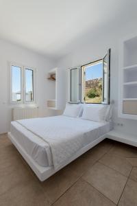 圣罗曼诺斯La Chapelle Ouest & Guest suite的白色的客房设有窗户,配有一张大白色的床。