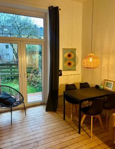 波鸿FeelsLikeHome - Stylische und zentrale Altbauwohnung mit Terrasse&Garten的一间带桌椅和窗户的用餐室