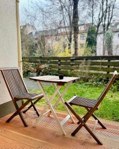 波鸿FeelsLikeHome - Stylische und zentrale Altbauwohnung mit Terrasse&Garten的甲板上摆放着一张桌子和两把椅子