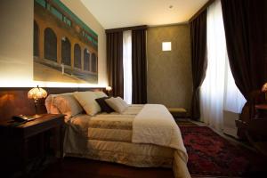 都灵德伊皮托利酒店的酒店客房设有床、桌子和窗户。