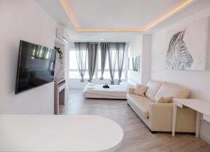 多列毛利诺斯Sun Apartments的带沙发和电视的白色客厅
