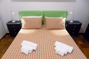 都灵Atriums Apartment Massaua的一张带两个白色枕头和绿色床头板的床