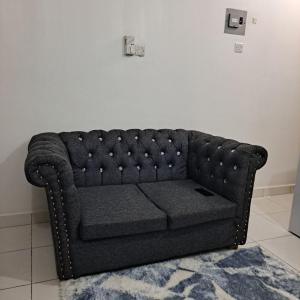 NdomeDolphin-holiday homes mombasa的一张黑色沙发,坐在一个地毯的房间