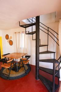 马哈赞加Le jardin des délices的螺旋楼梯,房间设有木桌和桌子