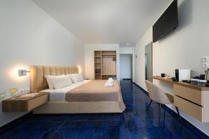 卡斯特罗西基亚Ninos Grand Beach Resort的一间卧室配有一张床、一张书桌和一台电视