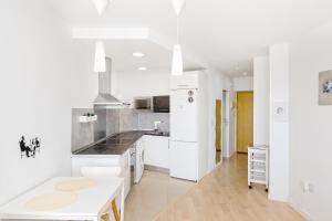 多列毛利诺斯Sun Apartments的厨房配有白色橱柜和白色台面