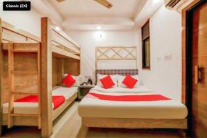 新德里OYO Flagship Hotel BalaG的一间卧室配有两张双层床和红色枕头