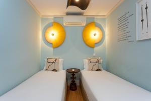 里斯本卡萨斯·拜萨 - 朱丽思和马德琳酒店的墙上灯的房间里设有两张床