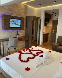 东吉托伊Hotel Comfort & Villas的一间卧室,床上有红色的鲜花