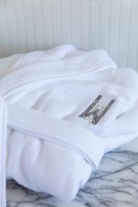 CarltonWherewithal Luxury Suites的一张白色衬衫,上面有一张照片,坐在床上