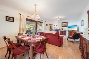 阿尔库迪亚Villa Manresa in Alcudia by JS Villas的客厅配有桌子和红色沙发