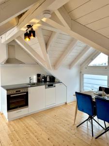布雷根茨Zentrale Wohnung mit Dachterasse的厨房配有白色橱柜和桌椅