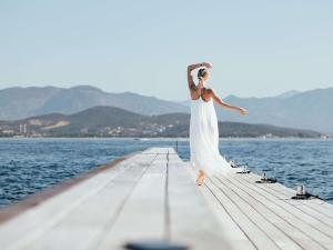 阿雅克修索菲特塔拉萨波迪西奥酒店的站在码头上身着白色衣服的女人