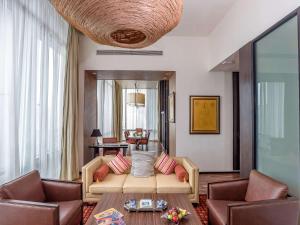 曼谷VIE Hotel Bangkok, MGallery的客厅配有沙发和两把椅子