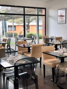 盖朗德城市 & Spa 贝斯特韦斯特酒店的餐厅设有桌椅和大窗户。
