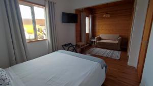 奥尔塔Porto Pim Guest House的卧室配有床、椅子和窗户。