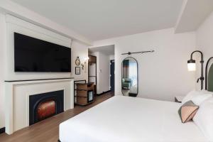 波士顿Onyx Boston Downtown的白色卧室设有一张大床和一个壁炉