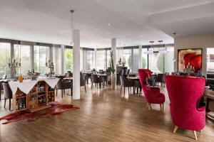 格拉茨Amedia Luxury Suites Graz, Trademark Collection by Wyndham的一间用餐室,配有红色的椅子和桌子