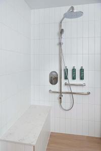 巴瑟尔顿Hilton Garden Inn Busselton的白色瓷砖浴室设有淋浴和柜台