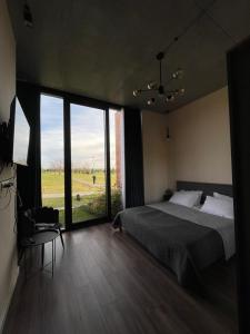 KachretʼiKakheti , Villa Ambassadori Kachreti Golf Resort的一间卧室设有一张床和一个大窗户