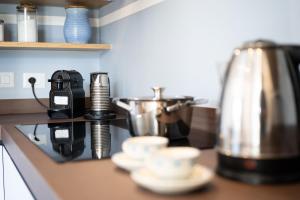 BagnaiaElbitat Homes的带杯子和咖啡壶的厨房台面