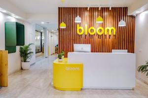 新德里Bloom Hotel - GK2的墙上有黄色桌子和花卉标志的办公室