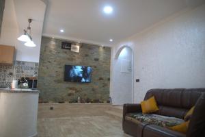 阿加迪尔Spacious Appartement in Agadir only for families的客厅配有沙发和石墙电视。
